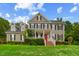 Charming two-story home with a well-manicured lawn, inviting porch, and a vibrant red front door at 809 Parkridge Dr, Clayton, NC 27527