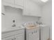 Well-lit laundry room with washer, dryer, sink, and ample cabinet storage space at 809 Parkridge Dr, Clayton, NC 27527