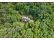 Aerial view of a home nestled within a dense, lush forest, showcasing the property's privacy and natural setting at 8232 Glynmorgan Way, Chapel Hill, NC 27516