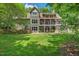 Expansive backyard with lush lawn, patio area, and a charming pergola covered deck, ideal for outdoor living at 8232 Glynmorgan Way, Chapel Hill, NC 27516