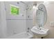 Bright bathroom features a classic pedestal sink, decorative accent tiles, and a tub/shower combo at 8232 Glynmorgan Way, Chapel Hill, NC 27516