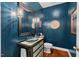 Stylish powder room featuring a glass vessel sink, modern fixtures, decorative mirror, and deep blue accent wall at 8232 Glynmorgan Way, Chapel Hill, NC 27516