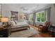 Bedroom with wood floors, a neutral color scheme, built-in shelving, and large windows with natural light at 8232 Glynmorgan Way, Chapel Hill, NC 27516