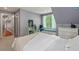 Cozy bedroom with built-in bench seating, soft grey walls, and views of backyard through many windows at 8232 Glynmorgan Way, Chapel Hill, NC 27516