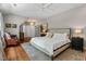 Spacious bedroom featuring a bed with soft white linens, hardwood floors, and a view of the hallway at 8232 Glynmorgan Way, Chapel Hill, NC 27516