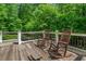 Spacious deck with rocking chairs and views of the mature trees surrounding the home at 8232 Glynmorgan Way, Chapel Hill, NC 27516