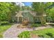 Charming two-story home featuring a stone walkway and beautifully landscaped front yard surrounded by mature trees at 8232 Glynmorgan Way, Chapel Hill, NC 27516