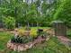 Picturesque garden featuring stone-lined flower beds, wood-chip paths, and a charming fence for a tranquil escape at 8232 Glynmorgan Way, Chapel Hill, NC 27516