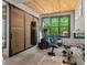 Home gym with wood ceiling, a sliding barn door and various exercise equipment at 8232 Glynmorgan Way, Chapel Hill, NC 27516