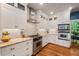 Modern kitchen featuring stainless steel appliances, white cabinets, and tile backsplash at 8232 Glynmorgan Way, Chapel Hill, NC 27516