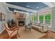 Inviting living room featuring hardwood floors, a stone fireplace, and ample natural light at 8232 Glynmorgan Way, Chapel Hill, NC 27516
