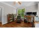 Bright home office with a ceiling fan, hardwood floors, and a window view of the lush, green outdoor space at 8232 Glynmorgan Way, Chapel Hill, NC 27516