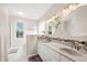 Bathroom featuring a double vanity with granite countertops, two round mirrors, and modern lighting fixtures at 8613 Swarthmore Dr, Raleigh, NC 27615
