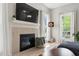 Living room fireplace with a large television and bright windows at 8613 Swarthmore Dr, Raleigh, NC 27615