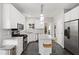Bright kitchen features white cabinets, stainless steel appliances, and an eat-in island with stool seating at 8613 Swarthmore Dr, Raleigh, NC 27615
