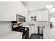 Updated kitchen featuring stainless steel appliances, white cabinets, mosaic backsplash, and black gas cooktop at 8613 Swarthmore Dr, Raleigh, NC 27615