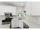 Modern kitchen with stainless steel appliances, white cabinetry, and backsplash, plus a convenient corner sink at 8613 Swarthmore Dr, Raleigh, NC 27615