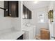 Laundry room featuring dark wood cabinets, countertops, washer and dryer, and a window at 8613 Swarthmore Dr, Raleigh, NC 27615
