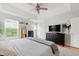 Large bedroom with a tray ceiling, ceiling fan, dark dresser, and natural light at 8613 Swarthmore Dr, Raleigh, NC 27615