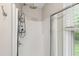 Modern shower showcasing a rainfall showerhead, a glass door, and built in shelving at 8613 Swarthmore Dr, Raleigh, NC 27615