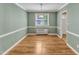 Light-filled dining room with hardwood floors, complemented by light green walls and white trim at 917 Saint Marys St, Raleigh, NC 27605