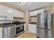 Efficient kitchen with white cabinets, stainless steel appliances, and tile flooring at 917 Saint Marys St, Raleigh, NC 27605