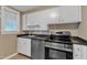 Galley kitchen features white cabinets, stainless steel appliances, and dark countertops at 917 Saint Marys St, Raleigh, NC 27605