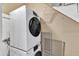 Laundry area with stacked washer and dryer next to some stored window screens at 917 Saint Marys St, Raleigh, NC 27605