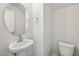 New powder room with pedestal sink, round mirror, and toilet at 919 Montague Ave, Durham, NC 27703