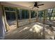 This back porch features wood flooring, a ceiling fan, and a view of the woods at 9254 Turkey Way, Middlesex, NC 27557