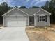 Charming exterior of a gray home with a white garage door, complemented by a well-maintained lawn and trees at 9254 Turkey Way, Middlesex, NC 27557