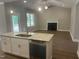 Open-concept kitchen showcasing granite counters, stainless appliances, and a seamless transition to the cozy living area at 9254 Turkey Way, Middlesex, NC 27557