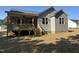 Rear exterior view of a grey house featuring a screened porch and stairs to the backyard at 9254 Turkey Way, Middlesex, NC 27557