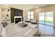 Bright living room with fireplace, built-in bookshelves, and sliding glass doors leading to the backyard at 93 Butterbean Ct, Zebulon, NC 27597