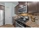 Gourmet kitchen featuring stainless steel appliances, granite countertops, and convenient access to the pantry at 94 Pearsall Farm Ln, Clayton, NC 27527