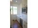 Butler pantry features white cabinets, white counters, stainless microwave and dishwasher, and a window at 976 Knob Hill Dr., Hillsborough, NC 27278