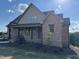 Charming brick home featuring a covered front porch, dark pillars, and well-maintained landscaping at 976 Knob Hill Dr., Hillsborough, NC 27278
