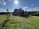 Exterior view of a two-story home featuring brick, landscaping, and a bright, sunny day at 976 Knob Hill Dr., Hillsborough, NC 27278