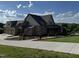 Exterior view of a two-story home featuring brick, landscaping, and a long driveway at 976 Knob Hill Dr., Hillsborough, NC 27278