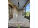Inviting covered front porch with brick flooring and dark wood columns offers scenic views at 976 Knob Hill Dr., Hillsborough, NC 27278