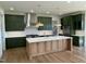 New kitchen features custom green cabinets, stainless appliances, white backsplash, and light wood island at 976 Knob Hill Dr., Hillsborough, NC 27278