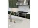 Kitchen features stainless steel appliances, green cabinets and mosaic backsplash at 976 Knob Hill Dr., Hillsborough, NC 27278