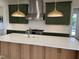 A kitchen island with a white countertop, stainless steel faucet and two gold pendant lights above it at 976 Knob Hill Dr., Hillsborough, NC 27278