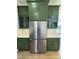 Kitchen with stainless steel refrigerator and green cabinets with gold hardware and mosaic backsplash at 976 Knob Hill Dr., Hillsborough, NC 27278