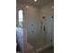 Modern shower with brushed bronze hardware, adjustable shower head, and tiled walls at 976 Knob Hill Dr., Hillsborough, NC 27278