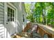 View of a shaded back porch with wooden railing and chairs, offering a peaceful outdoor space at 1003 E Club Blvd, Durham, NC 27704
