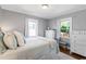 Cozy bedroom with natural light, hardwood floors, white dresser, and comfortable furnishings at 1003 E Club Blvd, Durham, NC 27704