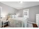 Comfortable bedroom with neutral tones, hardwood floors, a plush bed, and natural light from windows at 1003 E Club Blvd, Durham, NC 27704