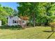 Quaint home surrounded by lush greenery and mature trees, showcasing its natural setting at 1003 E Club Blvd, Durham, NC 27704