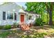 Charming single-story home with a well-manicured lawn, brick steps, and a vibrant orange front door at 1003 E Club Blvd, Durham, NC 27704